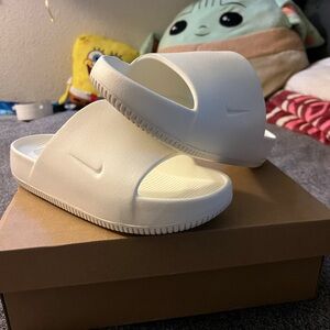 Nike calm size 10. Never once used. Brand new. Box is a little beat up.